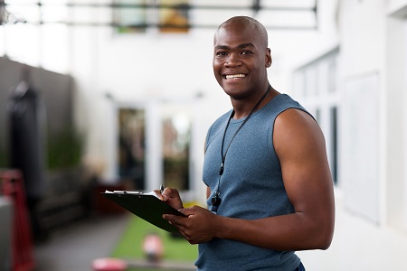 Male Trainer holding clipboard and smiling